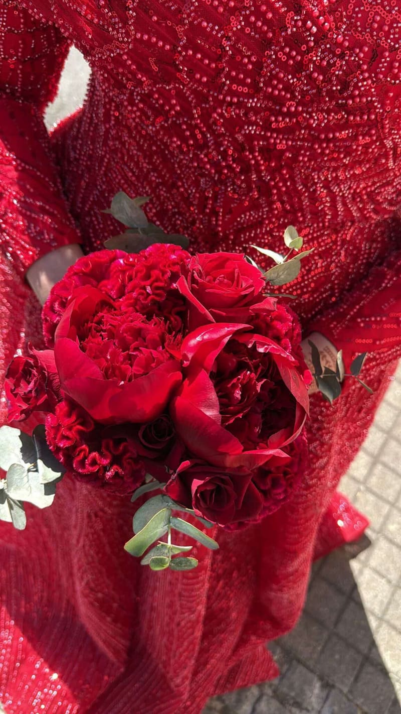 Roter Brautstrauß vor einem roten Paillettenkleid