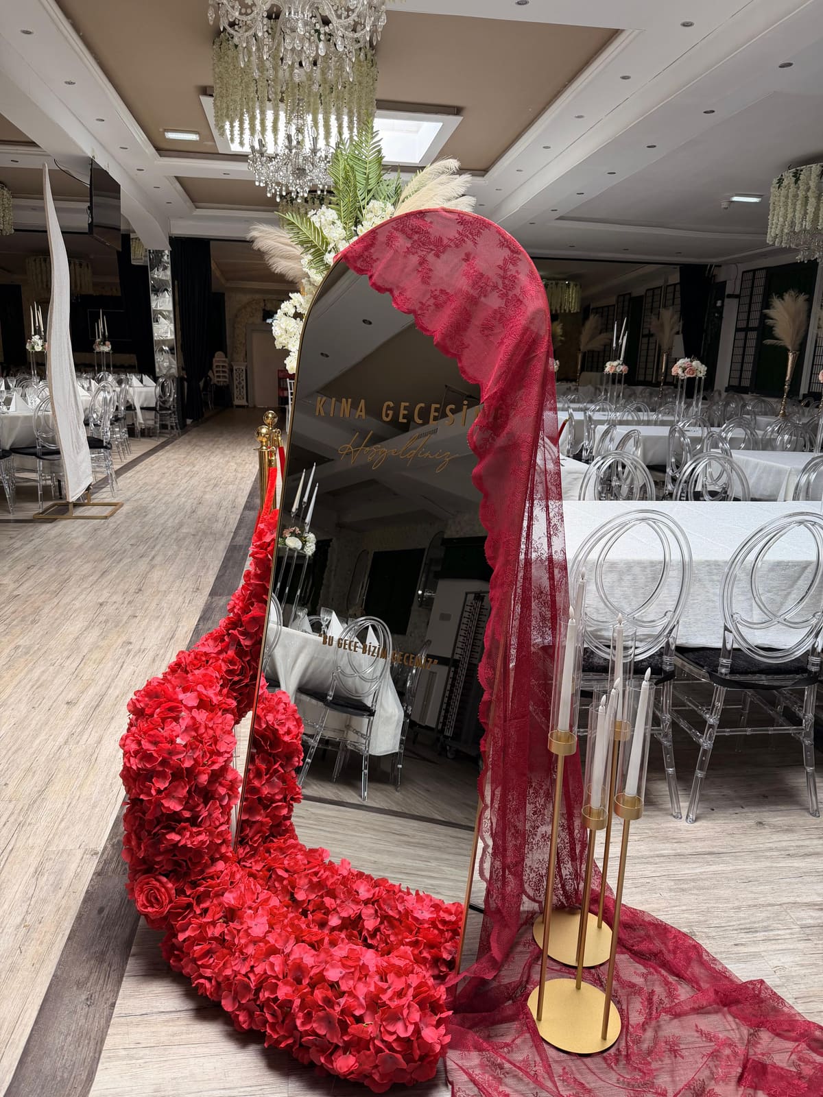 Bogenspiegel mit roter Spitze und roten Kunstblumen für eine Kına-Nacht